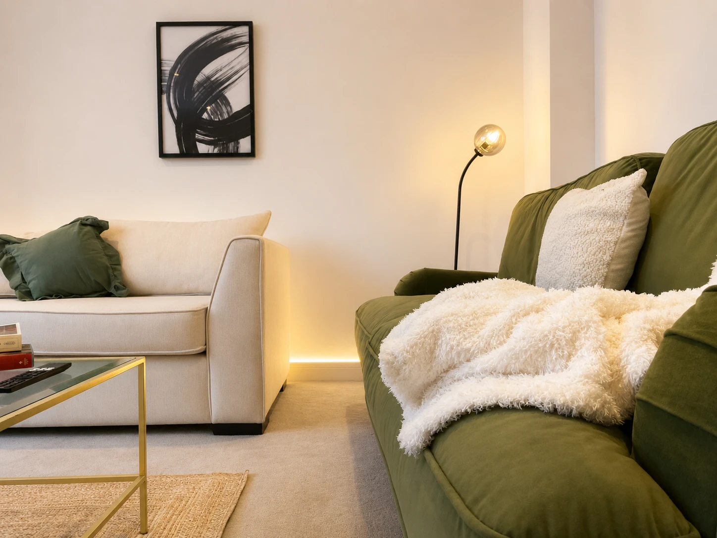 A finished living room with a green velvet sofa, designed by Nomi Atelier